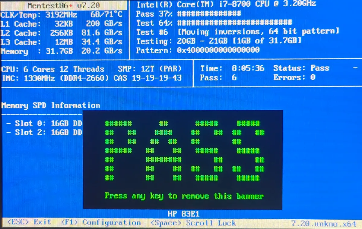 A physical photo of a monitor running Memtest86+, showing a bright green 'PASS' banner and zero errors.